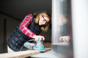 Young woman worker in the carpenter workroom.